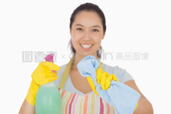 穿着围裙的快乐女人在她面前用布擦